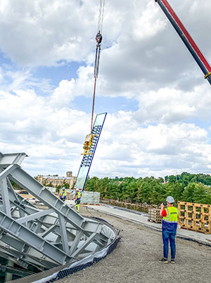 Le système d'aspiration Heavydrive soulève une vitre incurvée sous la structure en acier du centre de science et d'innovation de Kaunas