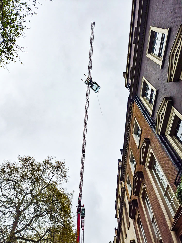 Le système à ventouse VSG 750 KRQ, équipé d'une vitre, est mis en place à l'aide d'une grue.