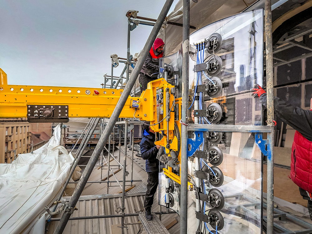 Pose d’une vitre ondulée à l’aide d’un système de levage à ventouses à vide sur une traverse de contrepoids. Droits d’image : Heavydrive.com